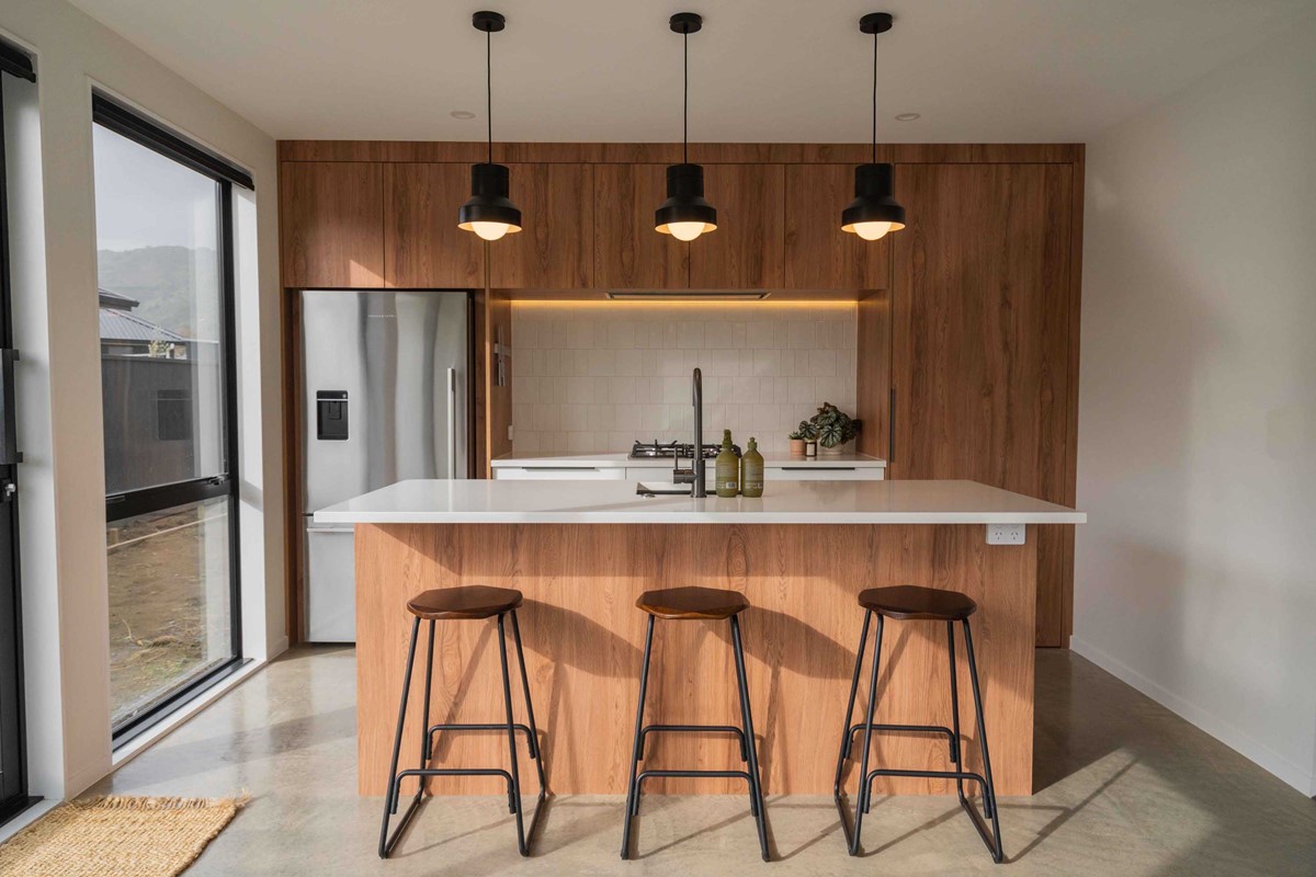 The warm kitchen with polished concrete flooring is one of the many features of the home which add to the overall vibe of Suhanya & Dan's home. To the right, behind the hidden door is the scullery which brings the kitchen to another level.